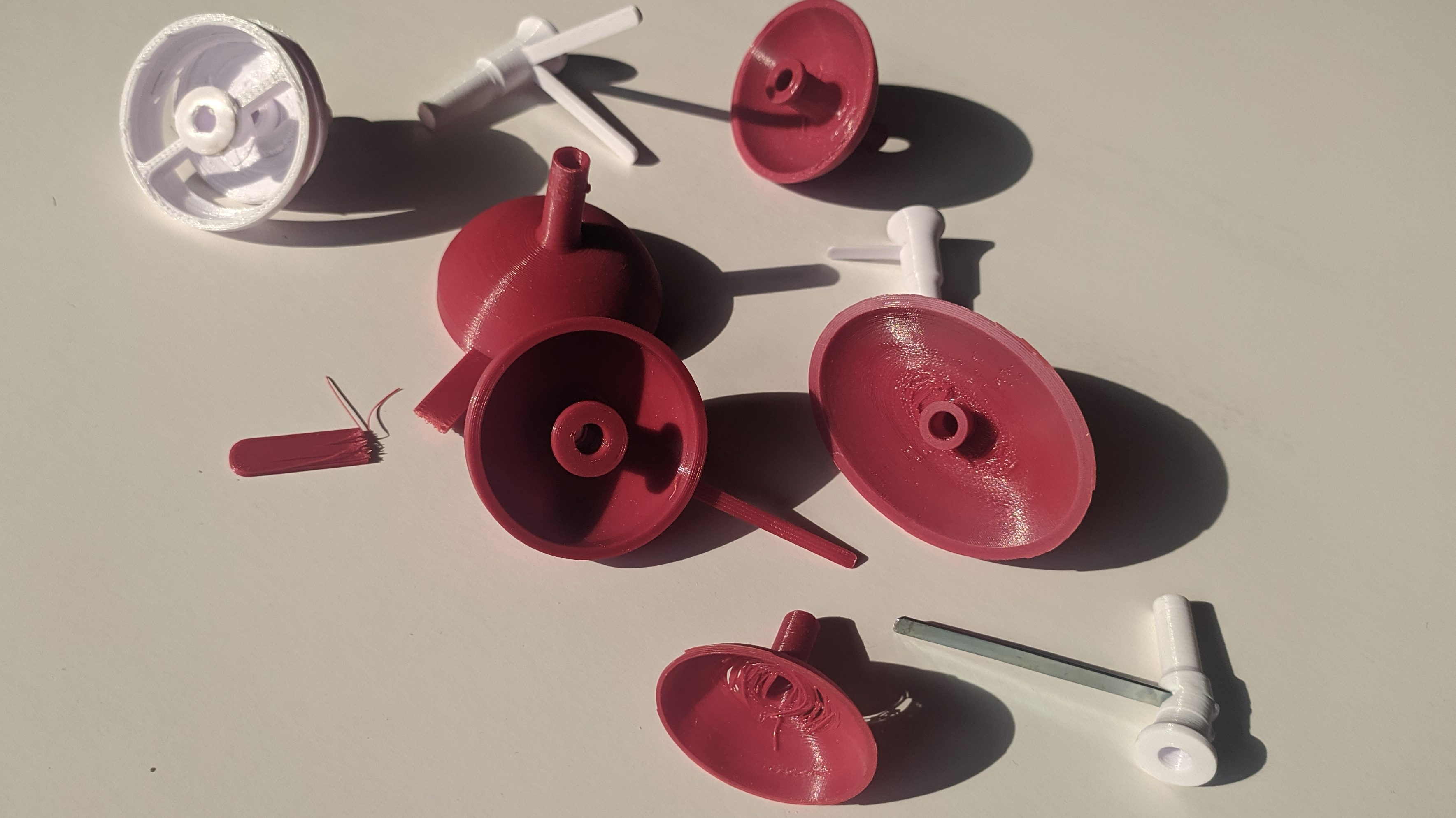 Shows a collection of failed tentative plastic 3d-printed mouthpieces designed by Alessandro Perini for his French horn piece.